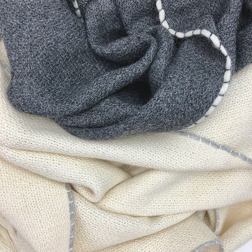 Close-up of gray and beige alpaca scarves with trim