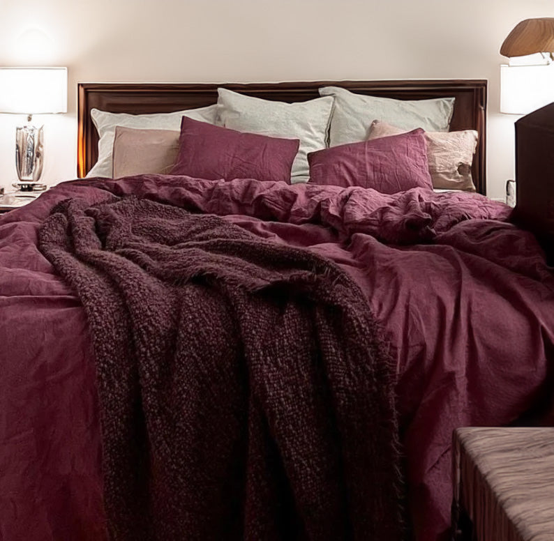 Bed with berry color linen cotton duvet cover and shams in a bedroom setting