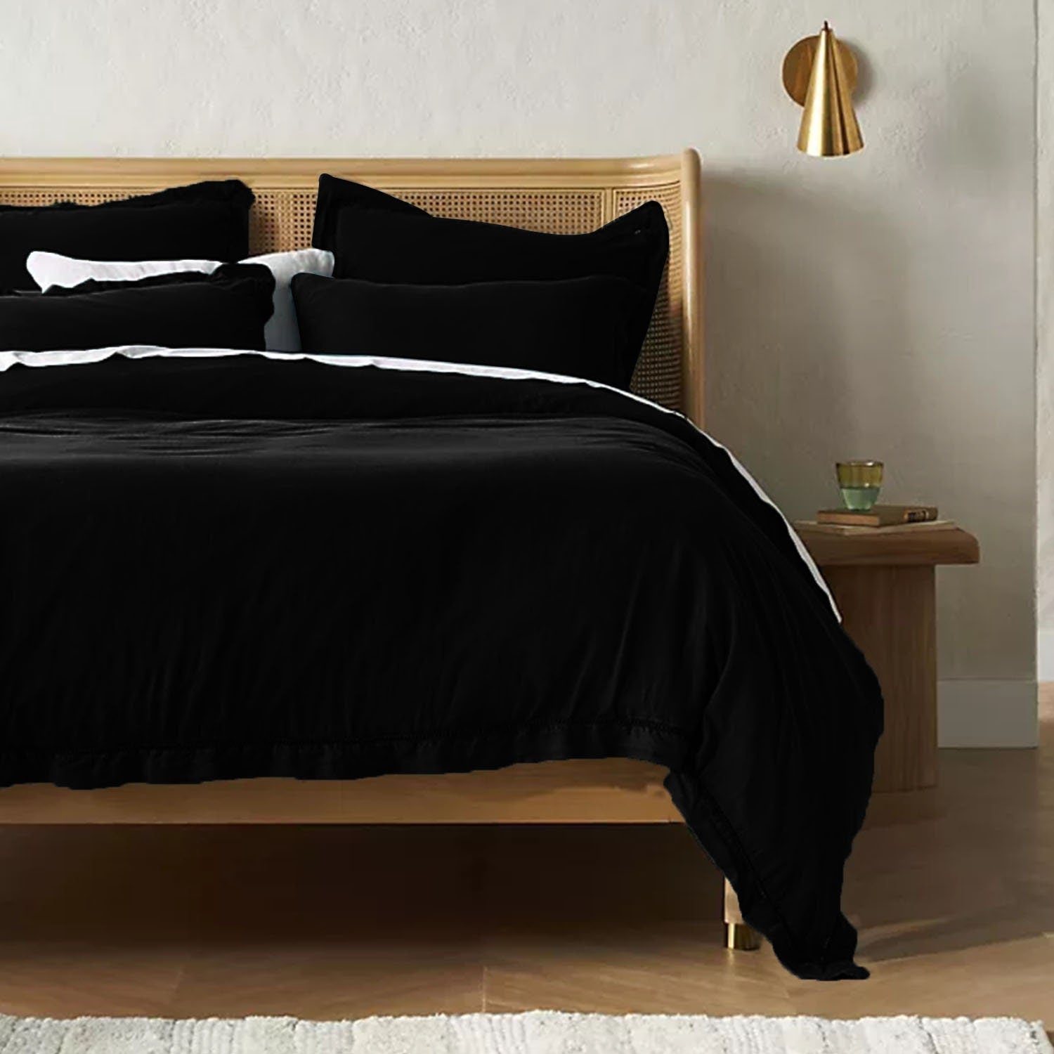 Bed with black linen and cotton duvet set and wooden headboard in a bedroom setting.