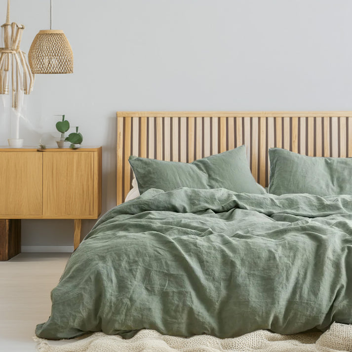 Bedroom with sage green linen and cotton duvet set and wooden furniture
